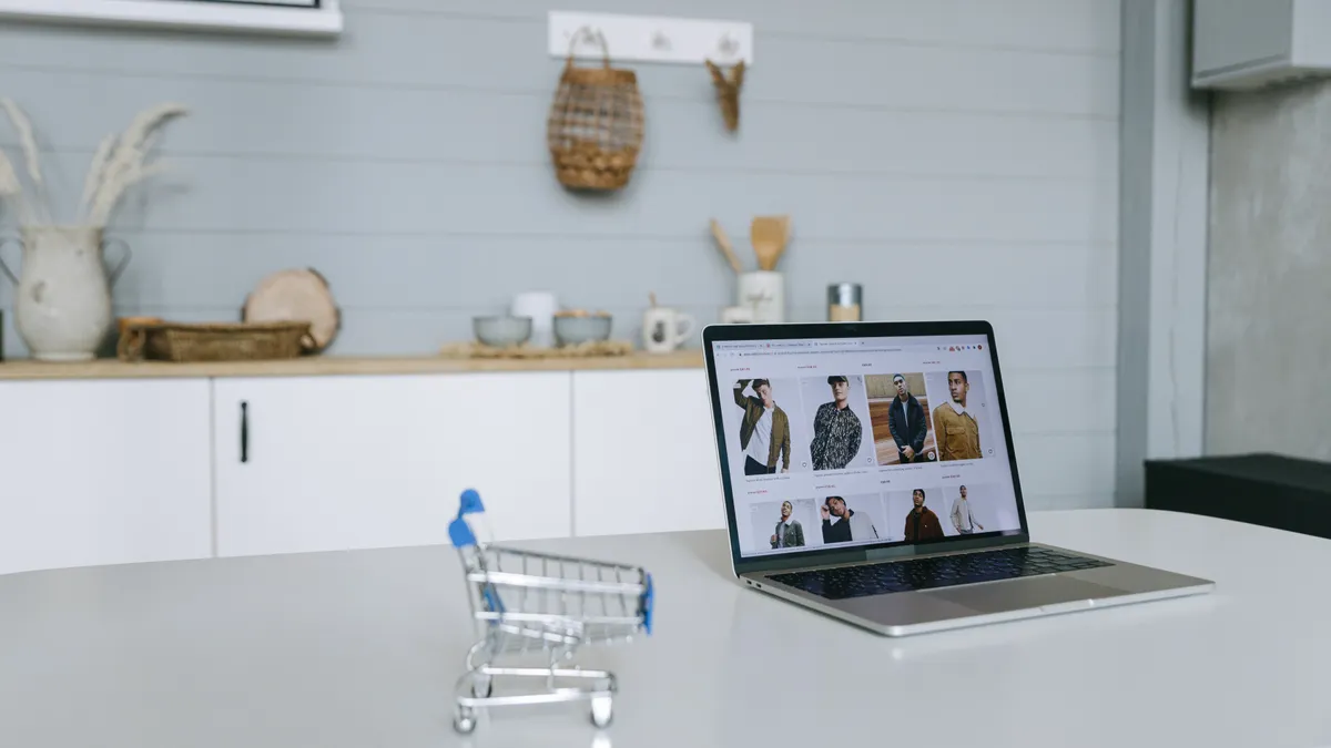 small shopping cart beside a laptop with product listings